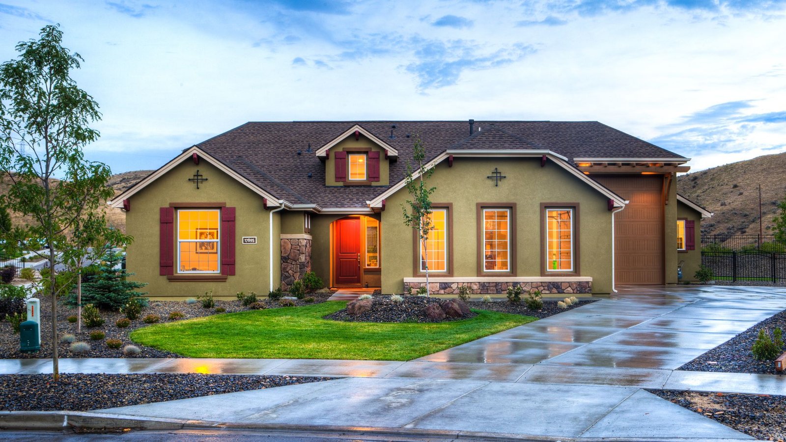Illuminated family home with a green lawn in the evening